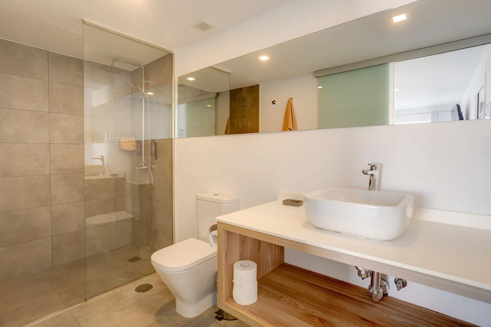 Apartment 118 bathroom, with a walk-in shower behind glass and a basin on an open wooden shelf