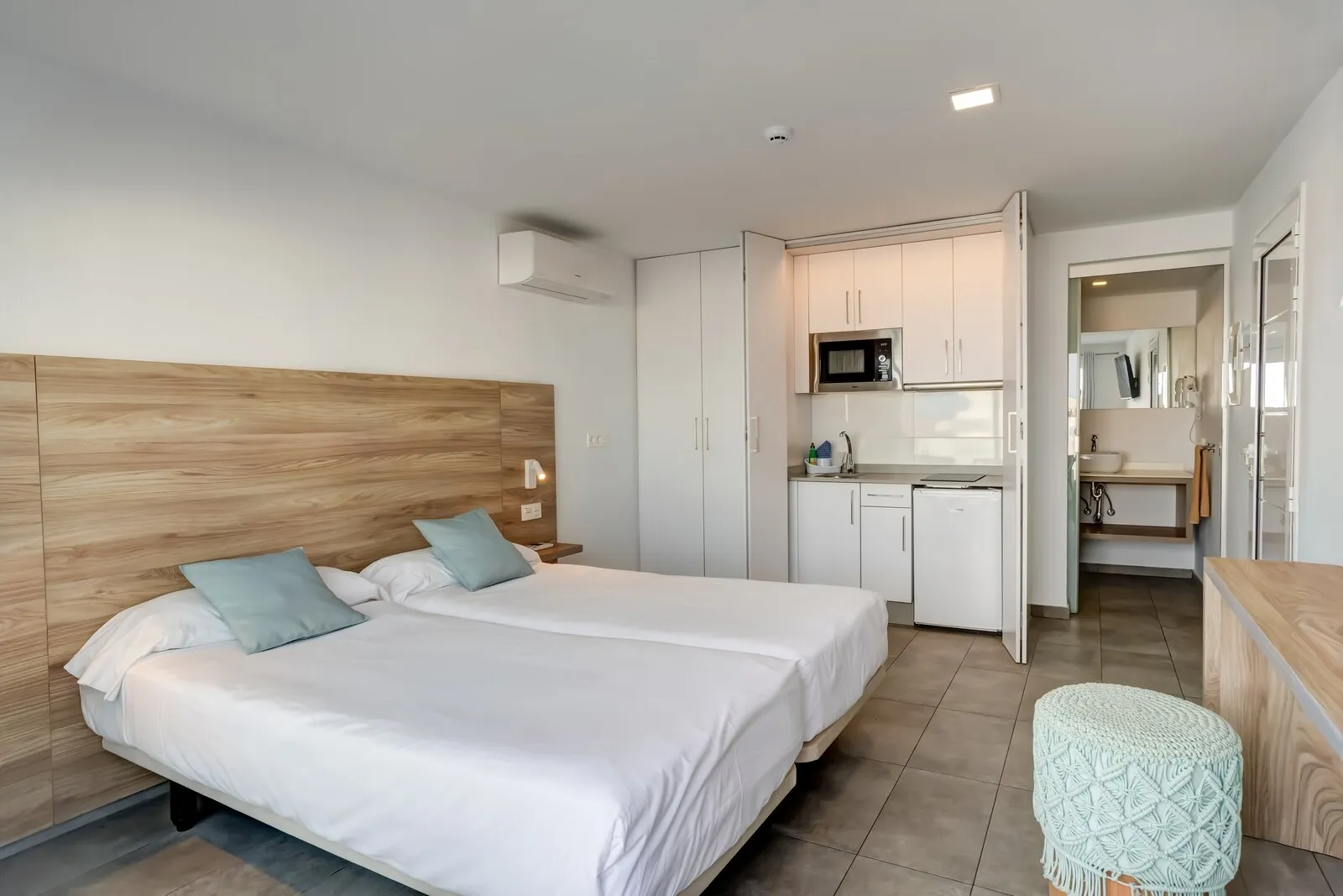 Apartment 118 from the bed, with the kitchenette beyond and the bathroom through the open door
